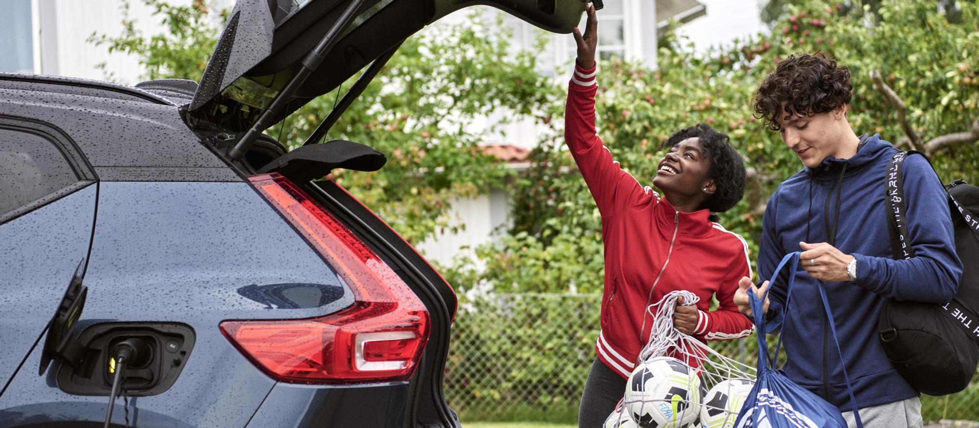 Young adults charging an electric car after soccer practice