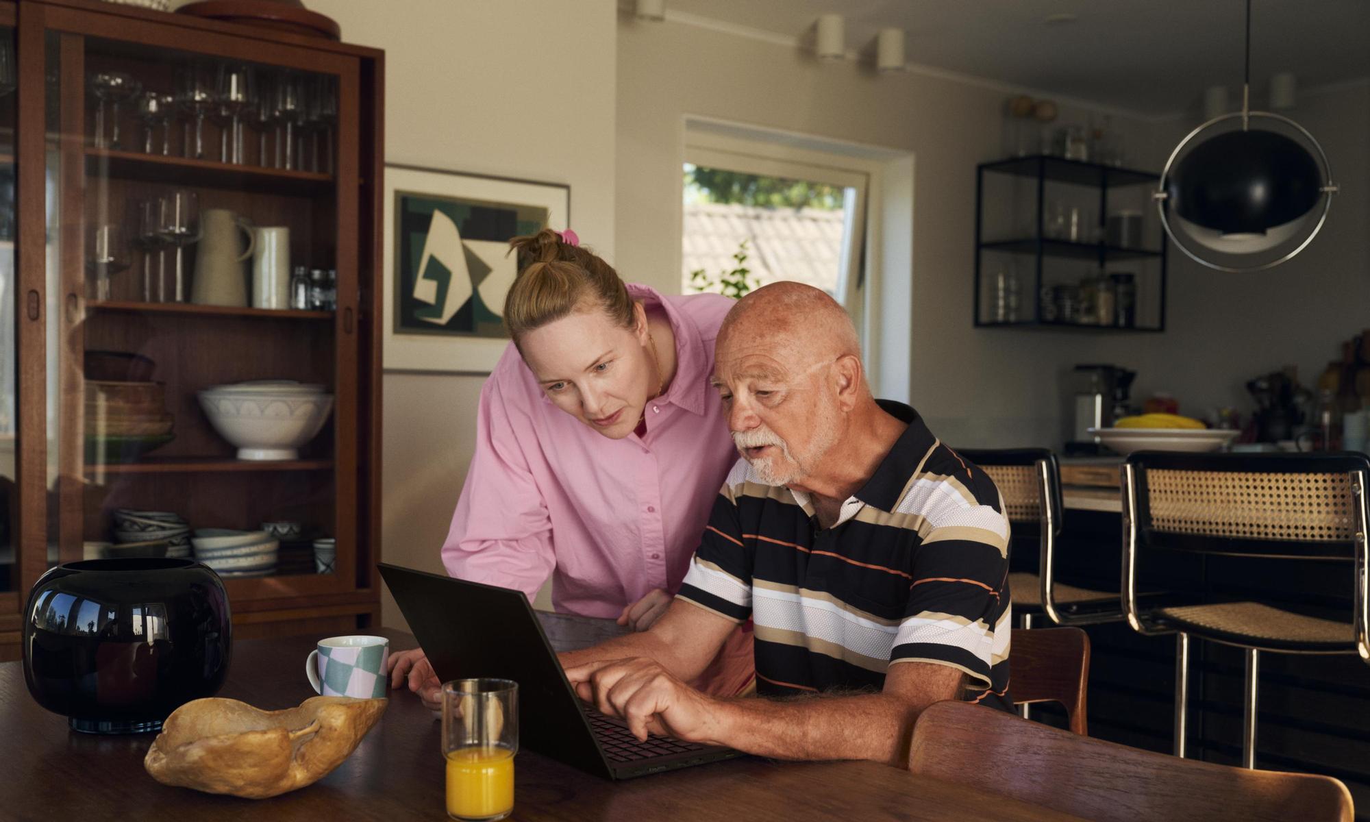 Two persons working together on a laptop